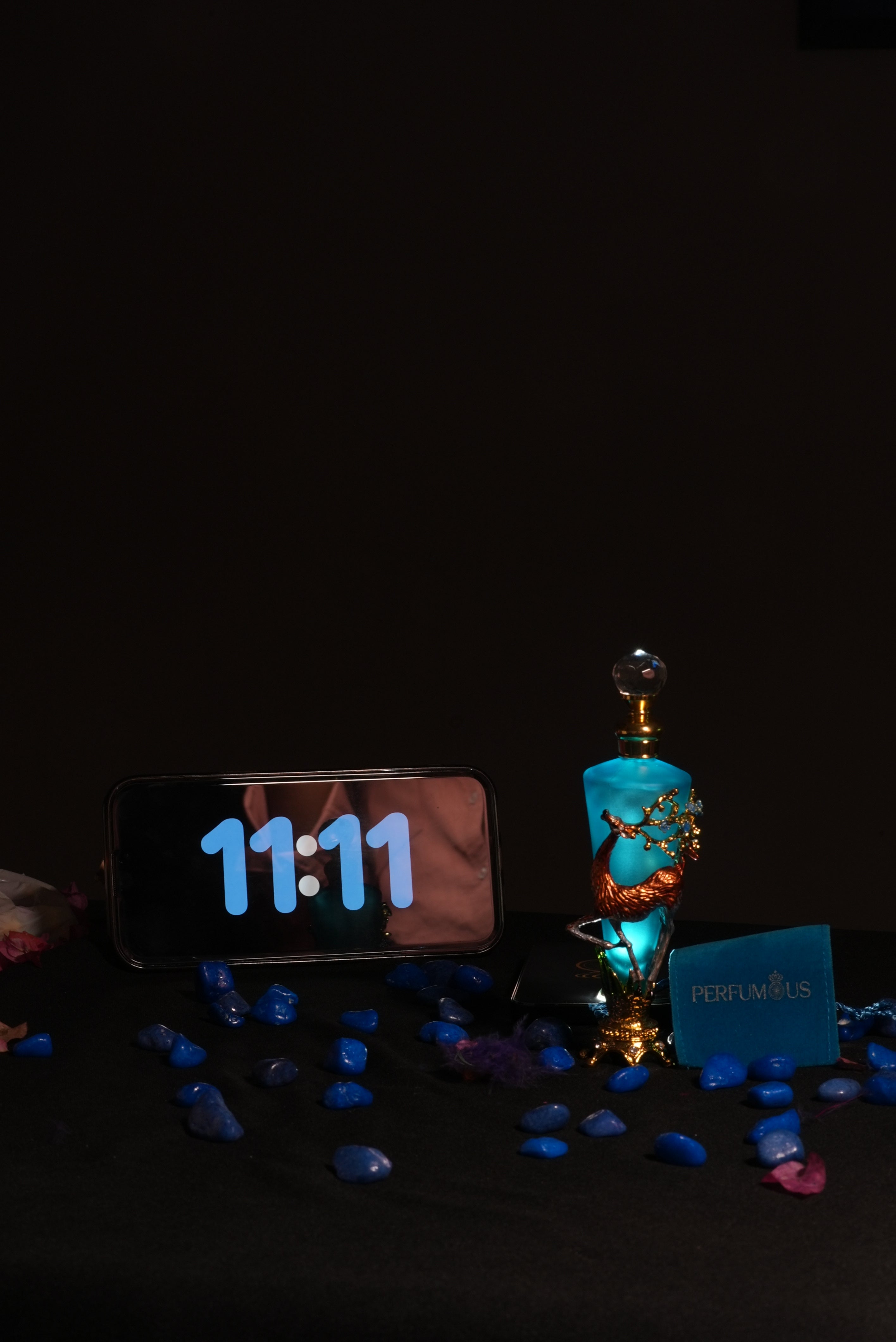A blue-tinted designer deer bottle of 11:11 Attar by Perfumous, representing synchronicity and pure luxury.