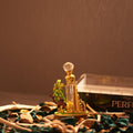 A golden Burj Al Arab designer bottle of Forest Oudh Attar by Perfumous, featuring a camel and palm tree.