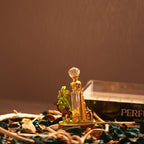A golden Burj Al Arab designer bottle of Forest Oudh Attar by Perfumous, featuring a camel and palm tree.