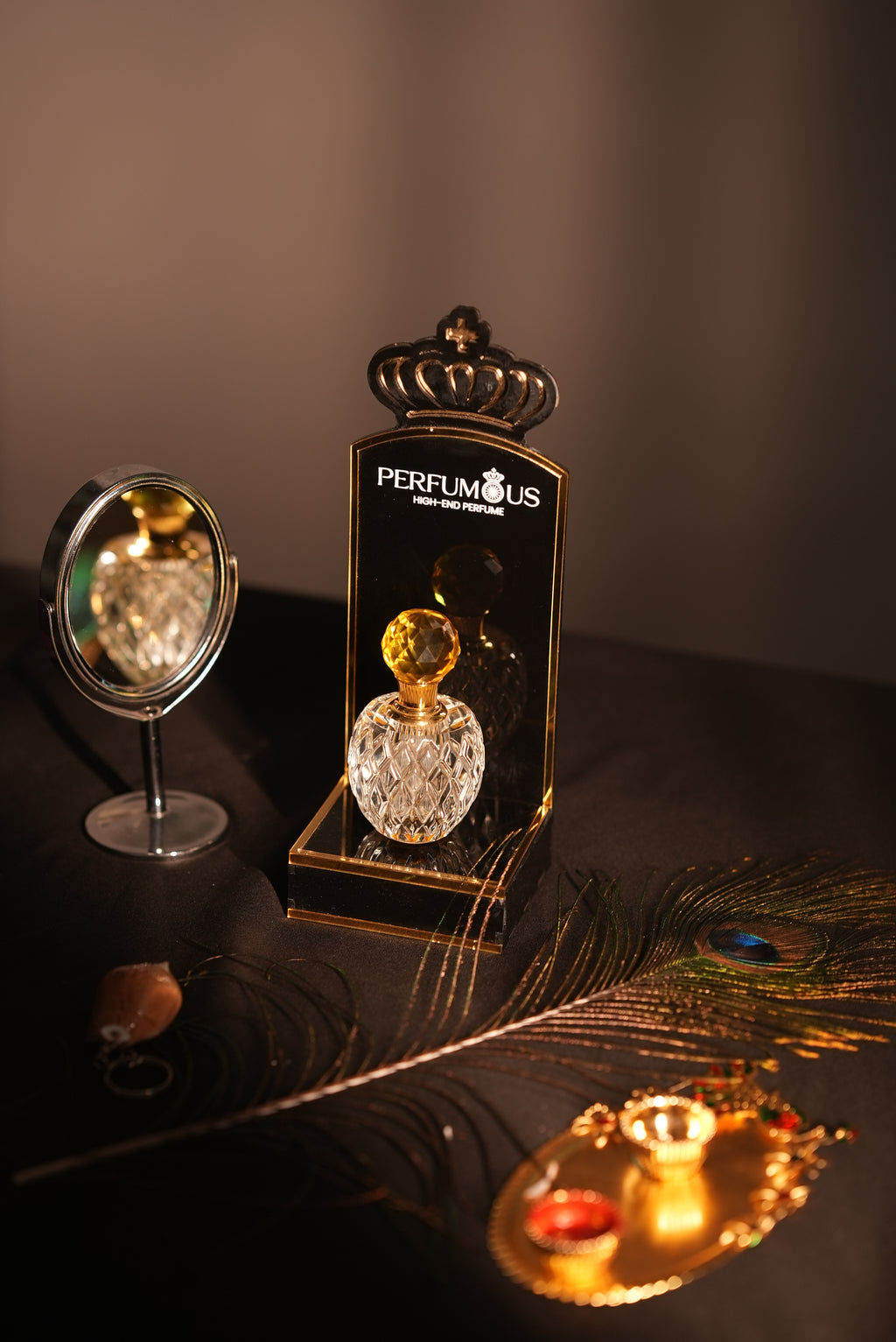 Peacock feather earring with a decorative stand featuring 'Pepinier' branding on a dark background.