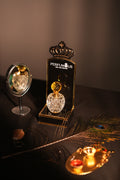 Peacock feather earring with a decorative stand featuring 'Pepinier' branding on a dark background.